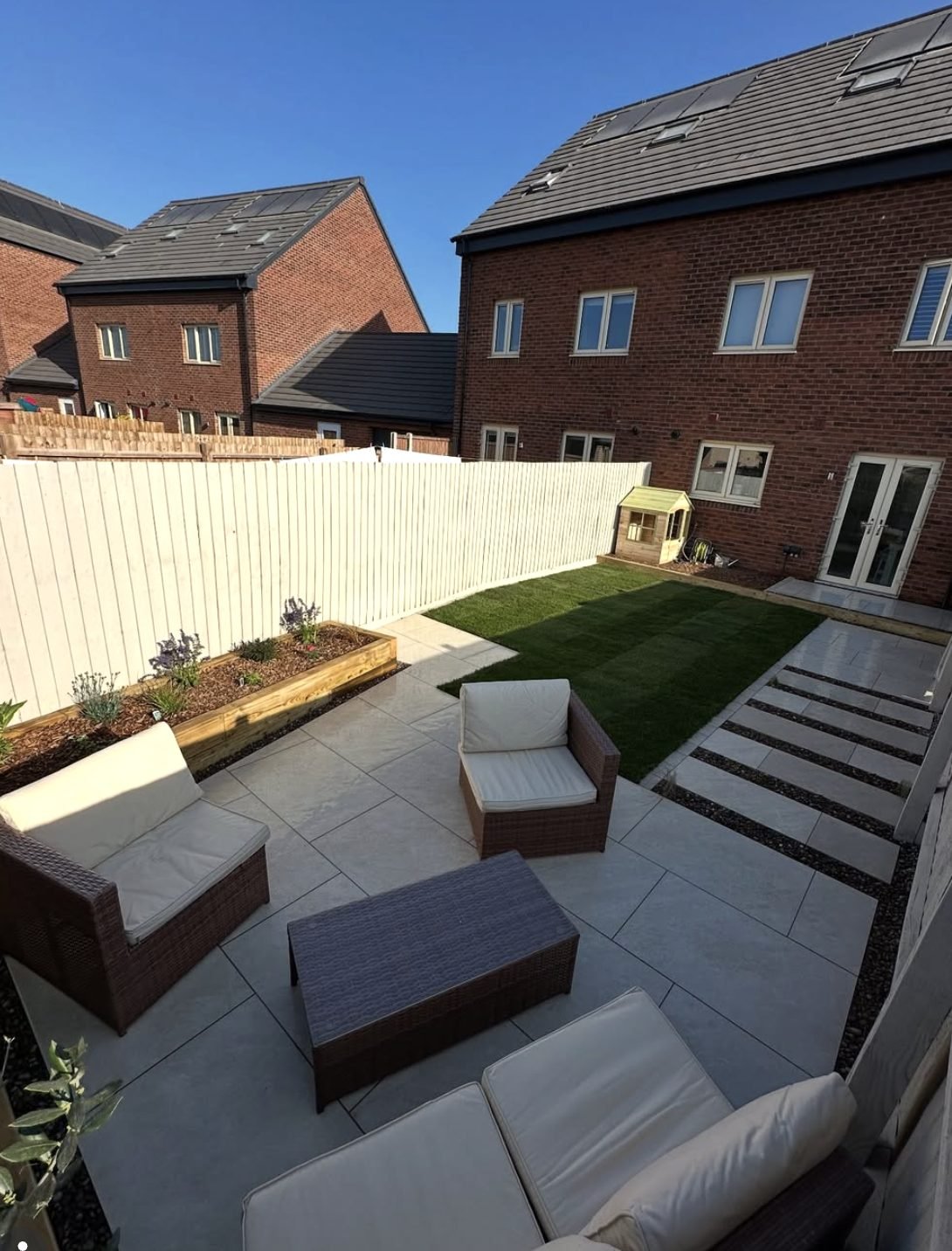 New build garden with porcelain patio, painted fence and fresh turf